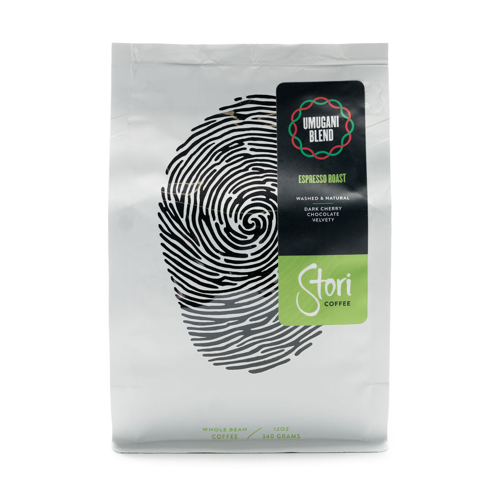 This picture shows an image of the front of our Umugani Espresso Roast. The bag is white with a black thumb print to symbolize our global connection. 